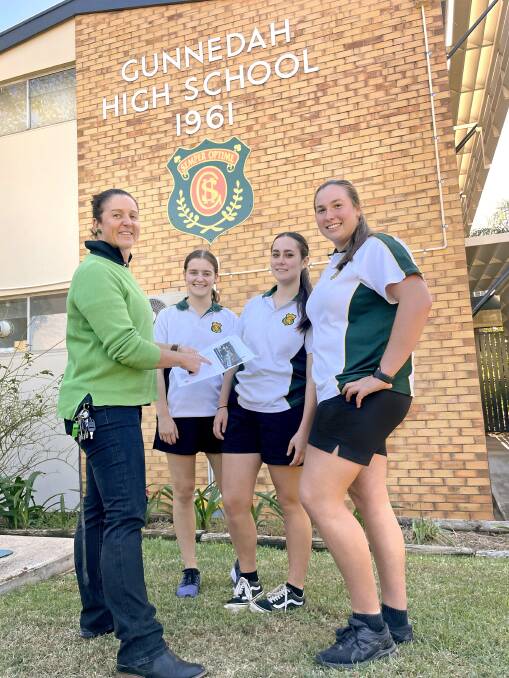 GREEN: Gunnedah High School deputy principal Beck Henderson and students Chloe Newman, Josie Gallagher, and Isabelle Moore check out the plans for the new panels. Photo: Supplied
