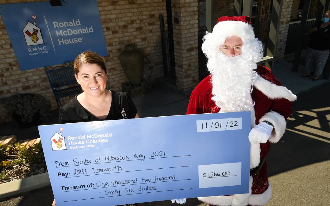FESTIVE FUNDS: Tamworth's Ronald McDonald House manager Rhiannon Curtis accepts a jolly donation from Nathan 'Santa' Peters. Photo: Gareth Gardner