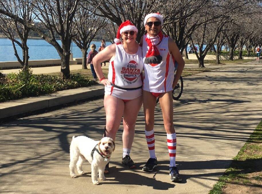 GOOD CAUSE: Heidi and the late Andrew Prowse with their dog Monty at the Santa Speedo Shuffle in Canberra. Photo: Supplied