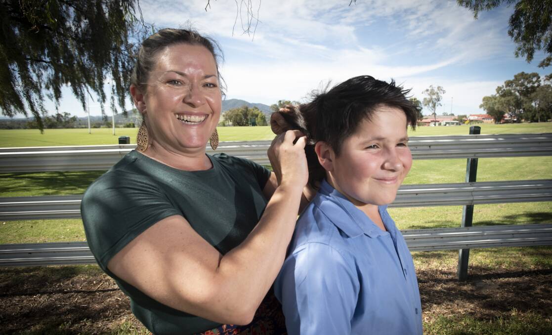 MOW THE MULLET: Teree Burr admires her son Alex's mullet before he cuts it off to raise money for Parkinson's Disease. Photo: Peter Hardin