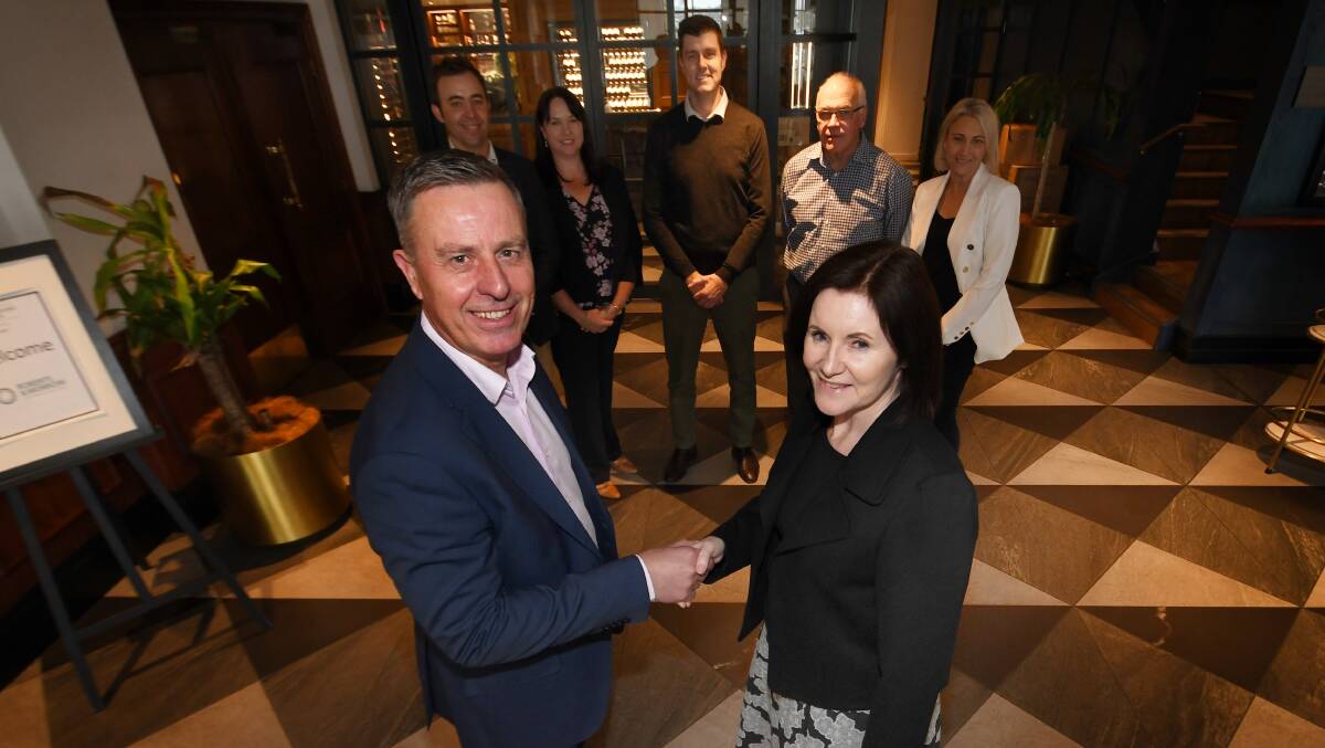 DONE DEAL: MMS partner Michael Smith and Roberts and Morrow partner Annette Aslin seal the deal to join forces and combine accounting firms. Photo: Gareth Gardner