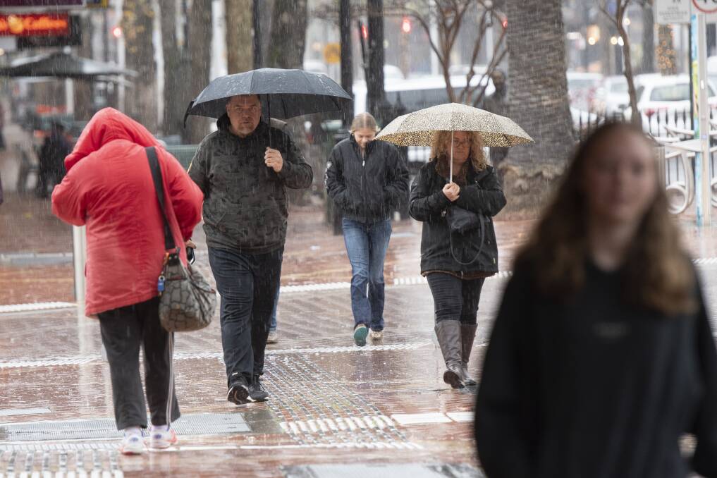People took cover from the rain on Monday morning in the Tamworth CBD. Picture by Peter Hardin.