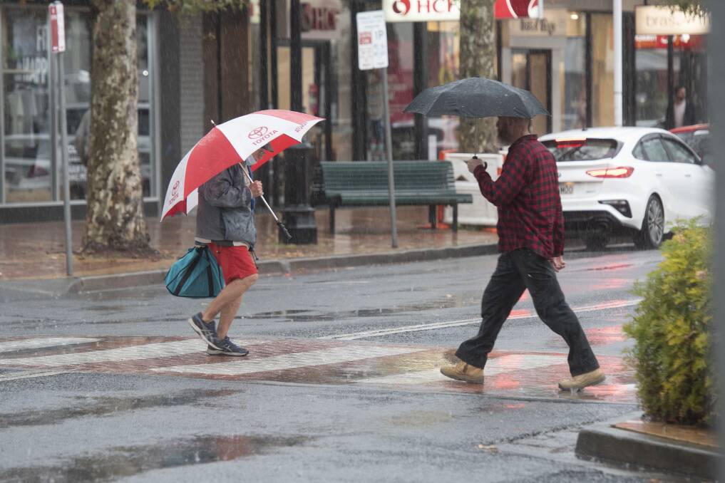 Pedestrians rush between cover in the Tamworth CBD. Picture by Peter Hardin.