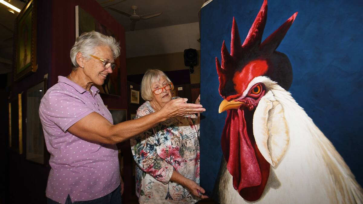 Bendemeer Art Show's Carol-Ann Brown and Margaret Hemming admire the bold colours of a painting on display. Picture by Gareth Gardner