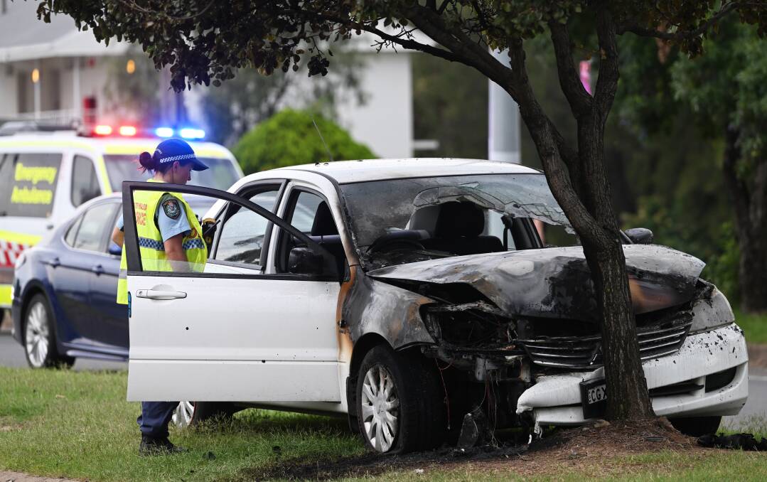 Car caught alight after crashing into a tree on the median strip along Goonoo Goonoo Road. Picture by Gareth Gardner
