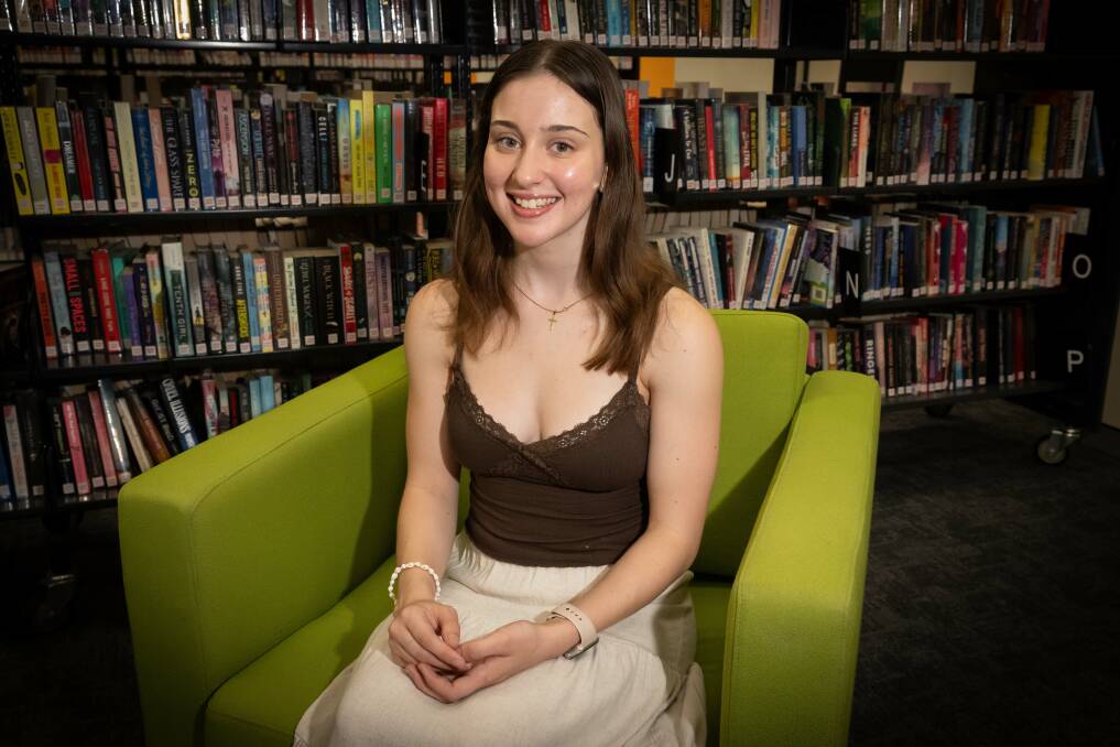 Eighteen-year-old Scarlett Coppola sits in the Tamworth Regional Library where her first book will be published. Picture by Peter Hardin