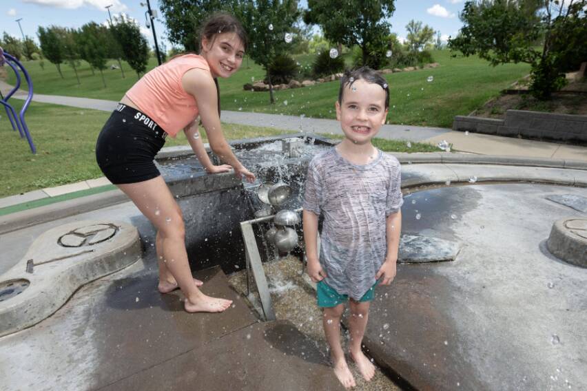  Local children Brier and Conar Russell cool off in the Tamworth Regionsl Playground. Picture by Peter Hardin.