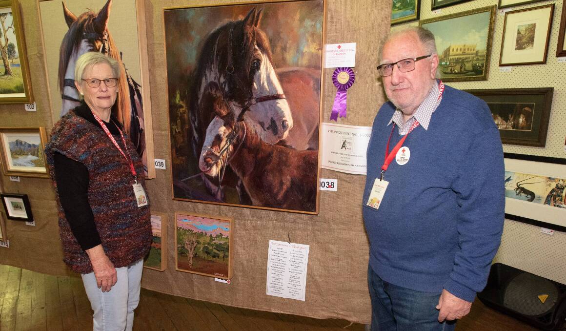 Sally Cronberger and Peter Willis-Jones stand next to the winning 2023 Currabubula Art Show painting, 'Just a Nibble', by Kathy Ellem. Picture by Peter Hardin