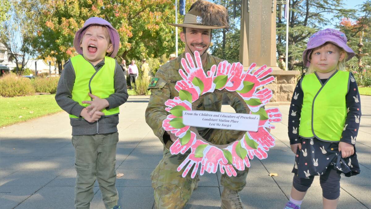  WREATH BEQUEATHED: Charles Crutchett, Corporal Michael Garrard, and Clancy Heycox-Marner with a handmade wreath from the children of Goodstart Early Learning Centre on Station Place. Picture: Kenji Sato
