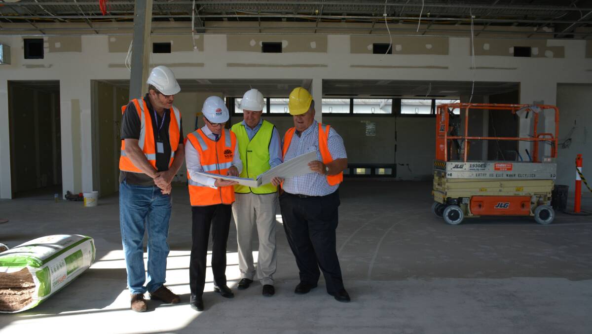 Armidale Regional Councillor Andrew Murat, left, Northern Tablelands MP Adam Marshall, TAFE Digital Program Director Gary Seach and Councillor Peter Bailey looking over the plans while inspecting the TAFE Digital Headquarters construction progress.