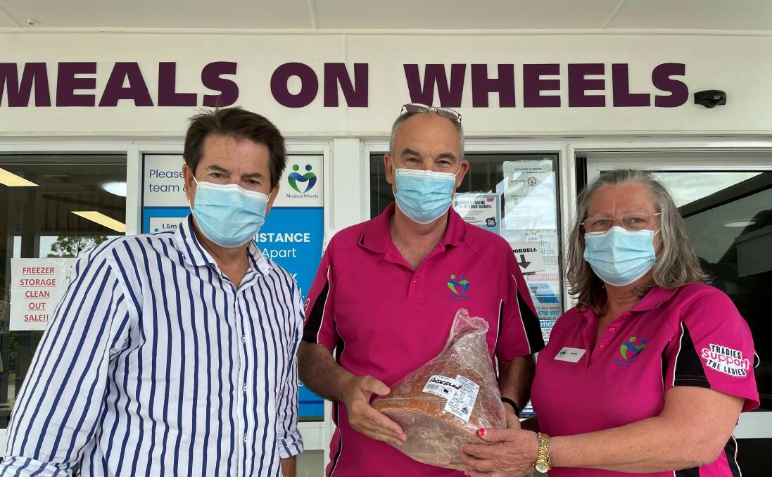 Helping hands: Kevin Anderson delivering a ham to Peter Gallaher and Brenda Steadman of Tamworth Meals on Wheels. Photo: supplied