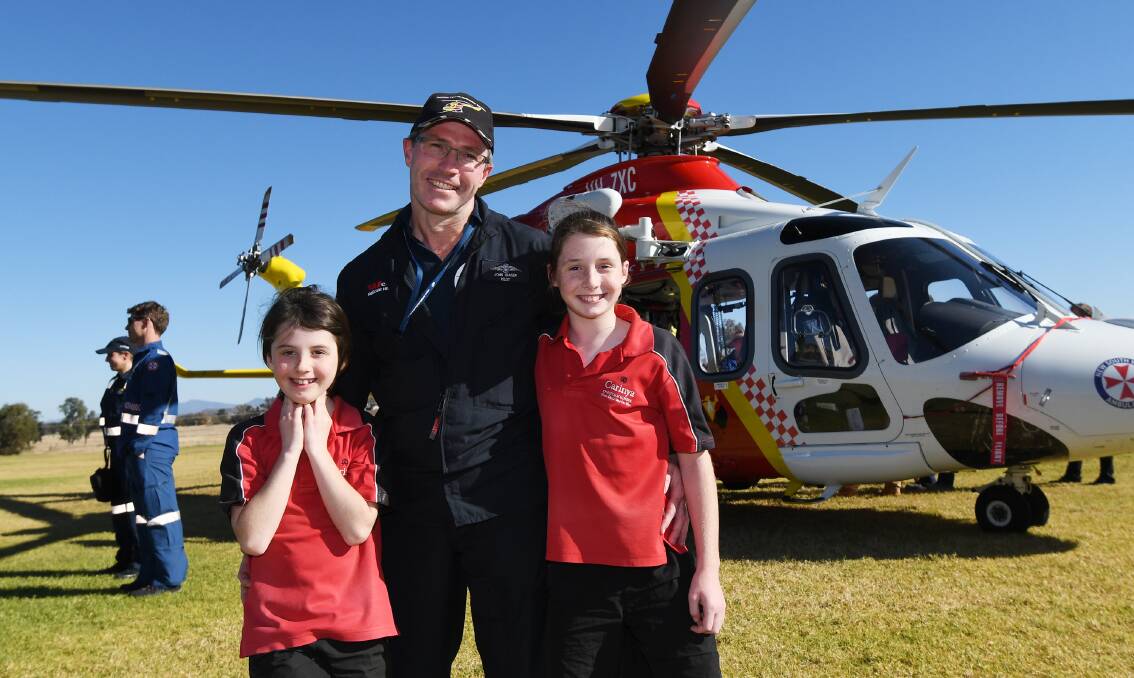 All smiles: Westpac Rescue Helicopter pilot, John Fraser, with his daughters, Charlotte and Mackenzie. Photo: Gareth Gardner 220518GGD01003
