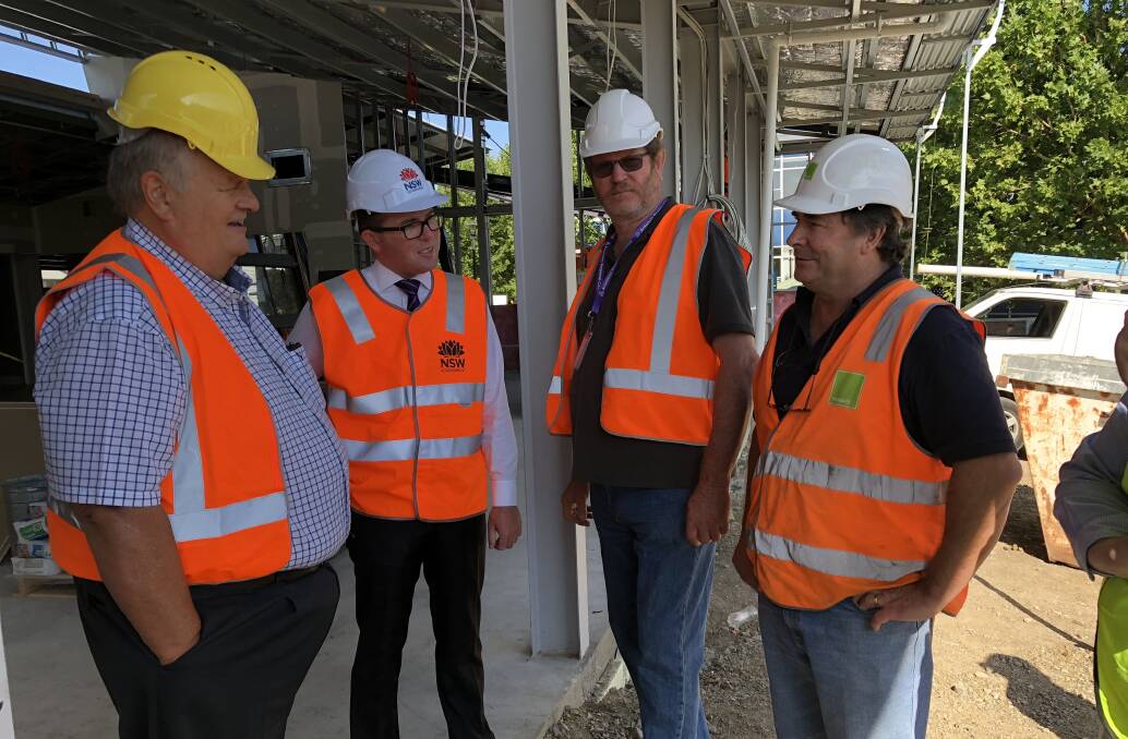 Councillor Peter Bailey, left, Northern Tablelands MP Adam Marshall, Councillor Andrew Murat and Site Manager Tony Lulhum discussing the TAFE Digital Headquarters construction progress.