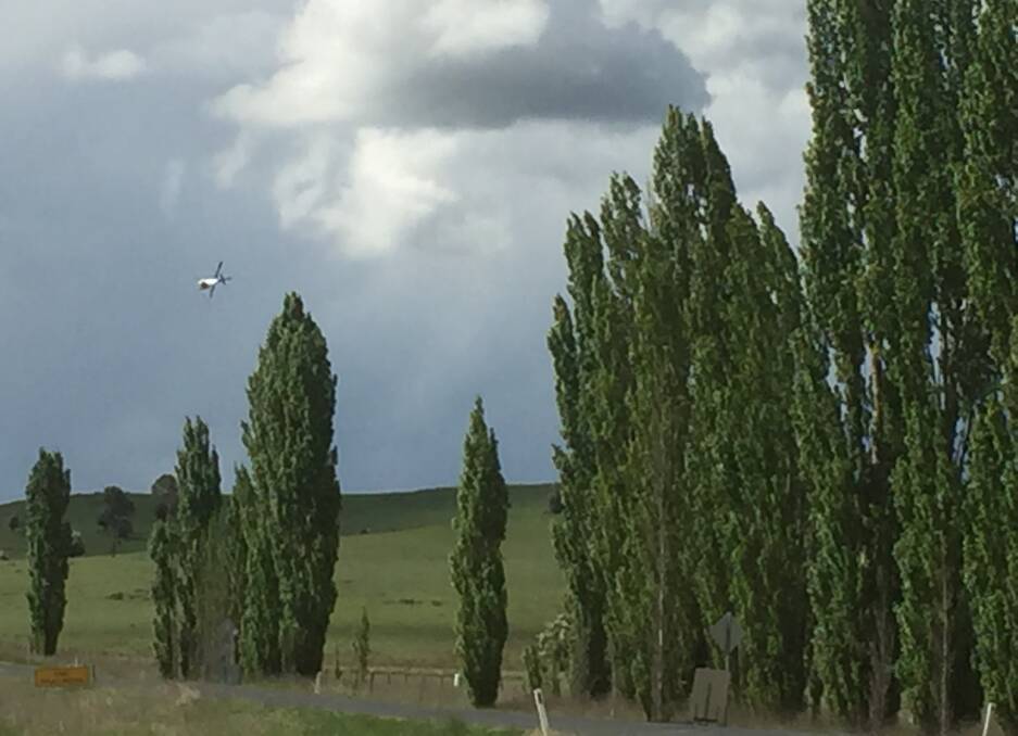 AERIAL ACROBATICS: A helicopter was doing some impressive low flying while spraying chemical on a property on the outskirts of Walcha last week. Photo: Stephanie van Eyk