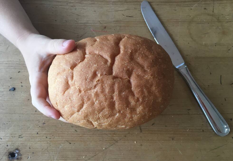 Proof is in the pudding: A test loaf of bread in the hand of a six-year-old. Photo: Ingrid Roth.