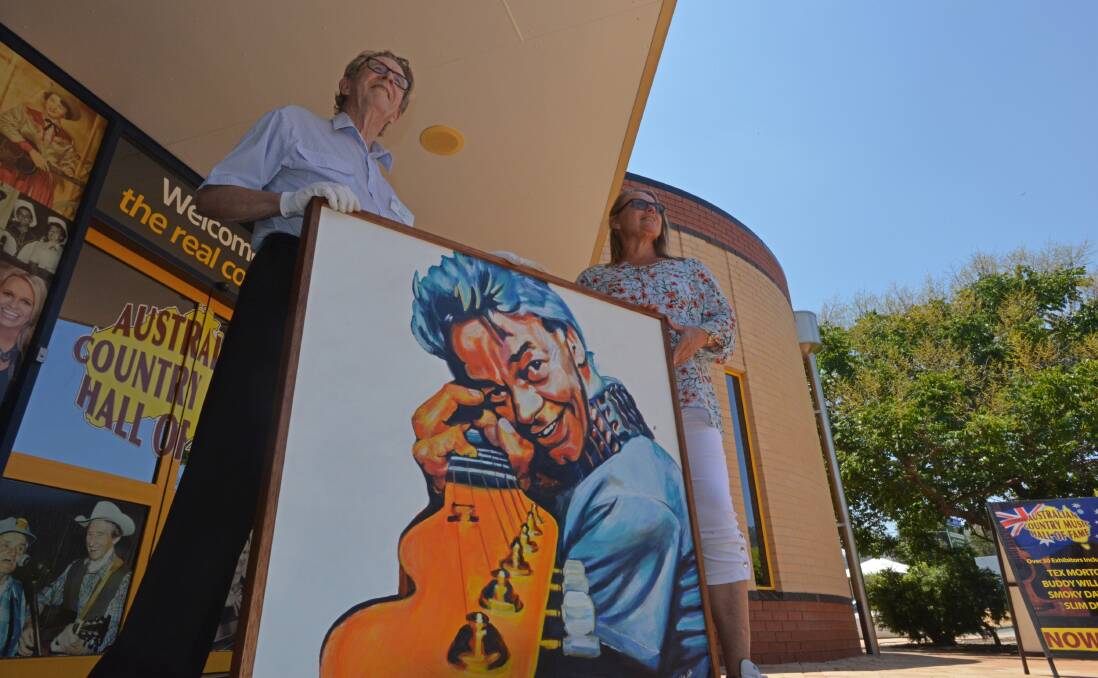 TRIBUTE: Country Music Hall of Fame archivist Eric Scott and artist Helen Lahdensuo with the portrait of the late Phil Emmanuel. Photo: Ben Jaffery