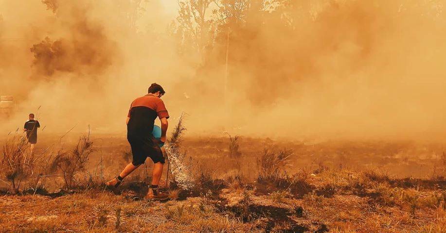 ALL HANDS ON DECK: Firefighters and residents tried to make the most of the slight easing in conditions on Sunday. Photo: Talaya Abbott