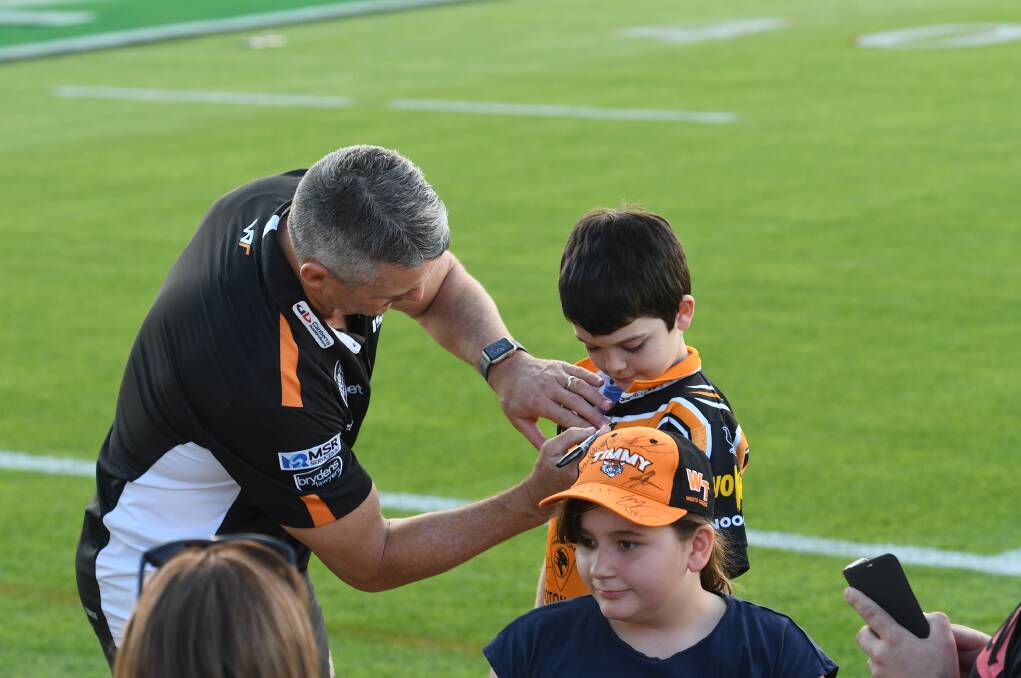 STAGE SET: Tigers' coach Ivan Cleary signs the jersy of young fan Patrick Belt at Scully Park. Photo: Gareth Gareth.
