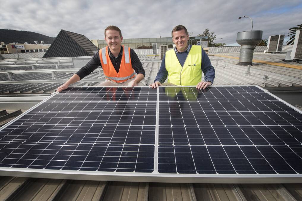 BRIGHT IDEA: Solar installer and Tim Culver and centre manager Mitchell Phelps with the first of the 800 panels that will be placed on the roof of the Tamworth Square shops. Photo: Peter Hardin
