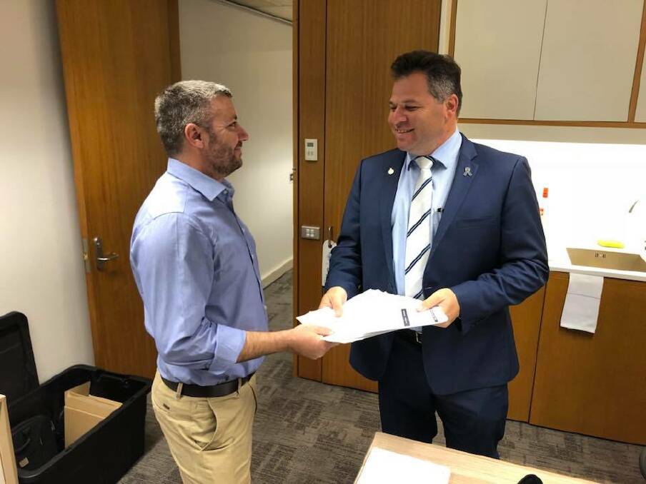WHEELS TURNING: Jeff Bacon presents the petition to Shooters Orange MP Philip Donato.