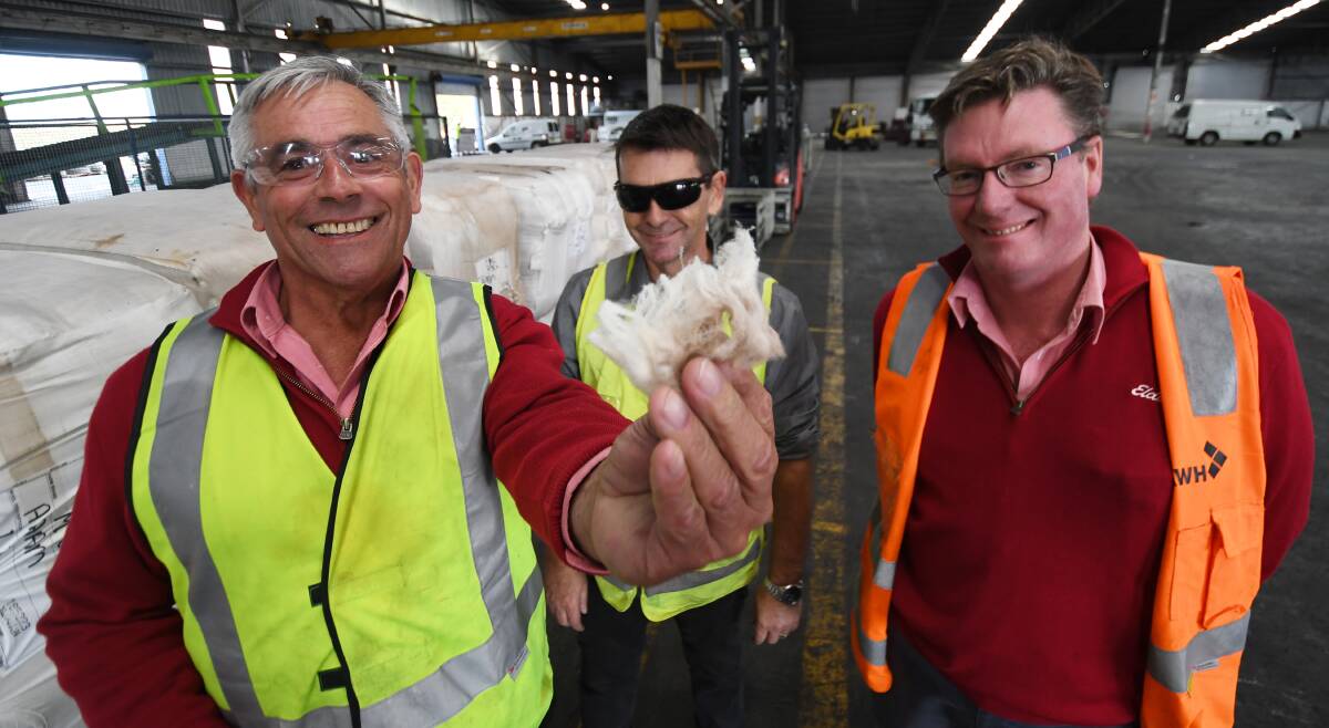 LIGHT AND FLUFFY: Elders district wool manager Tom Henry and AWH site manager George Wright with John Goudge. Photo: Gareth Gardner 030619GGC03