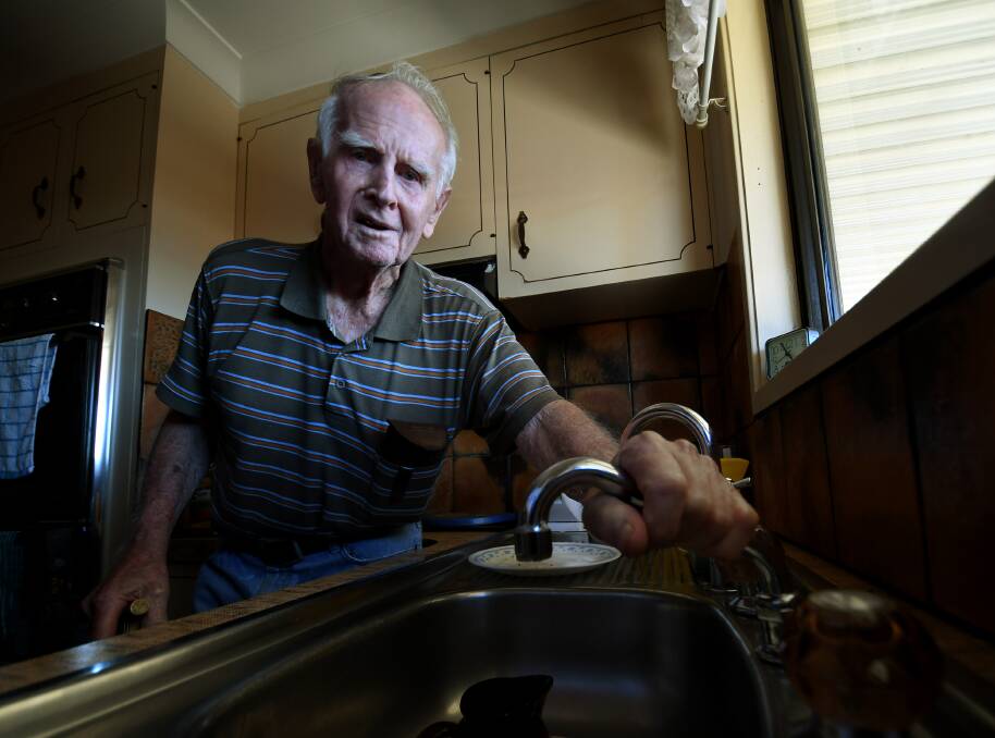 HARD WATER: Pensioner Dick Ranclaud can't move his tap because it's clogged stiff with calcium - one of the many problems the town's water has caused. Photo: Gareth Gardner