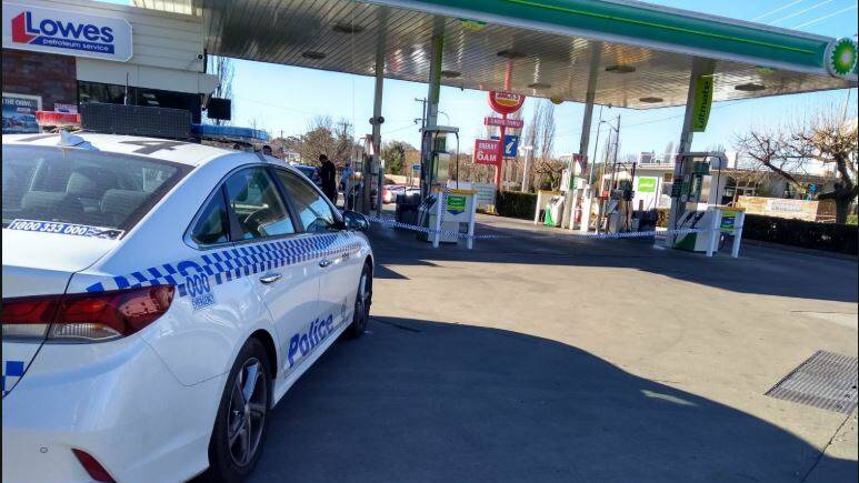 Guilty plea: Detectives and police examine the BP service station off Marsh Street in Armidale after the July 23 robbery. 