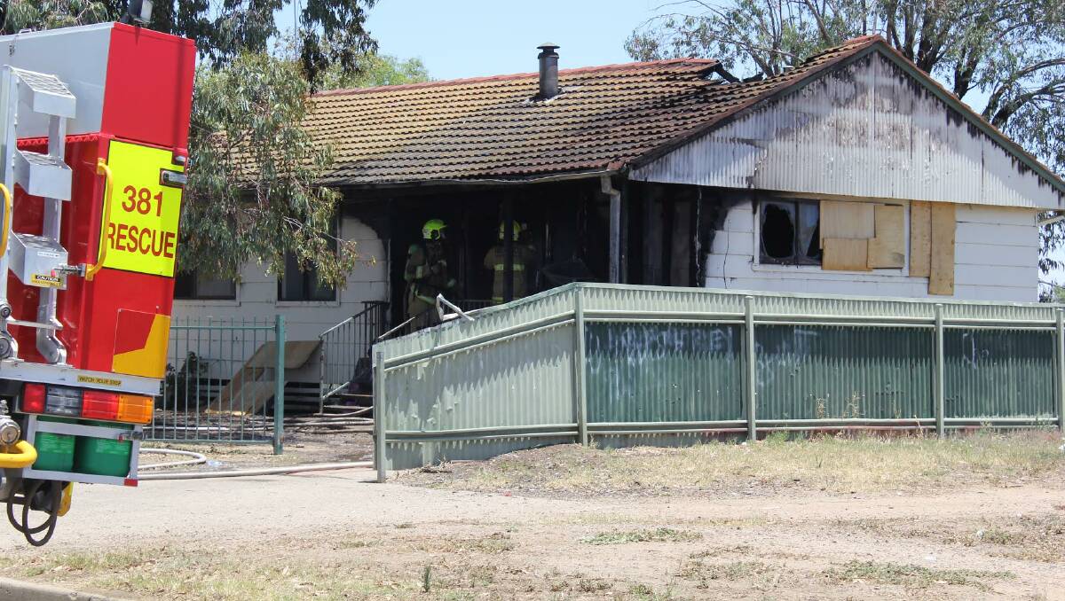 Suspicious blaze: Firefighters mop up the fire which took hold of the Arunga St house on Friday. Photo: Sophie Harris