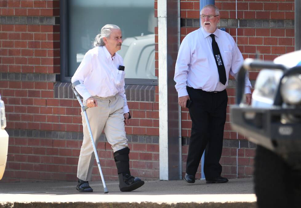 Self-represented: Chris McKinney, who walks with a single crutch, with a friend outside Tamworth District Court for the start of his trial on Monday. Photo: Gareth Gardner