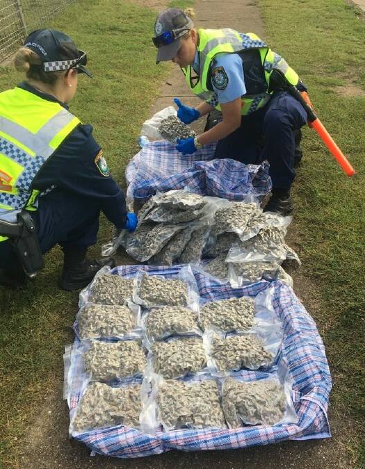 Seizure: New England police with the bags of what police allege is cannabis on the side of the road in Boggabilla. Photo: NSW Police