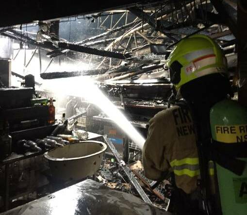 Suspicious blaze: A Fire and Rescue NSW firefighter extinguishes the blaze inside The Armidale Club. The coroner has ruled the fire was deliberately lit after traces of petrol were found at the scene. Photos: Supplied