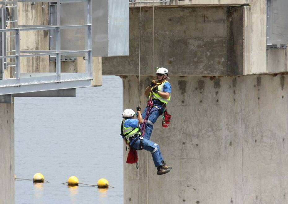 On the up: Two rescuers are lifted back up the morning glory spillway during the training exercise. Photo: State Emergency Service