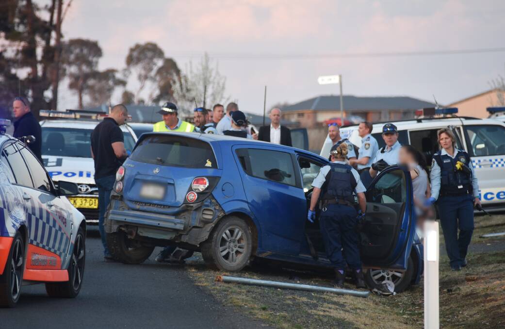 Under arrest: Police at the scene where a man and woman were pulled from the Holden  after it crashed on Post Way outside of Armidale on September 12. Photo: Laurie Bullock