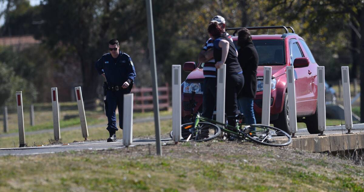 Crash scene: A police officer and witnesses at the site on the Oxley Highway at Westdale on Tuesday. Photo: Gareth Gardner