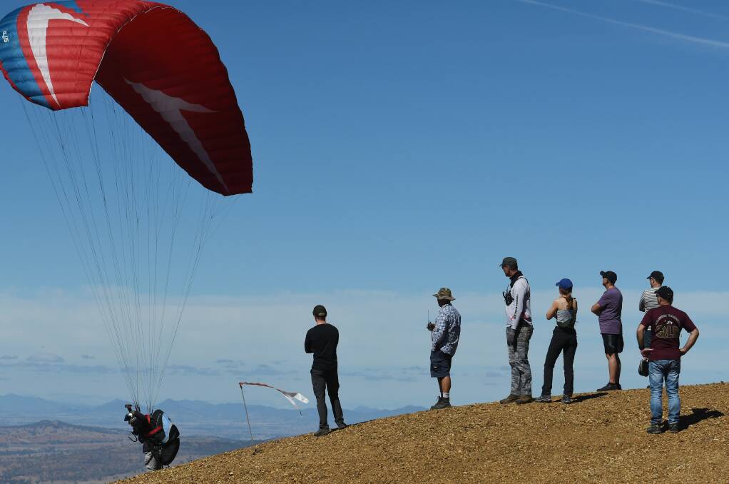 Taking off: A pilot sets off from Mount Borah on Friday morning as spectators watch on. Photo: Gareth Gardner 190419GGA10