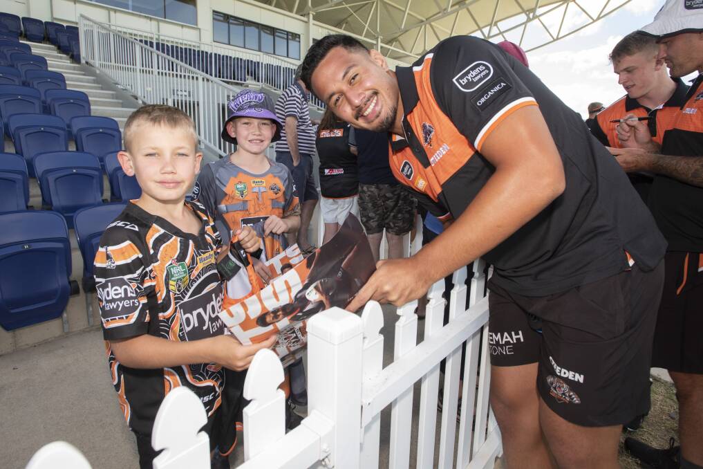 Superstar encounter: Tyler and Parker O'Neile get up close with Wests Tiger player Kelma Tuilagi at Scully Park. Photo: Peter Hardin