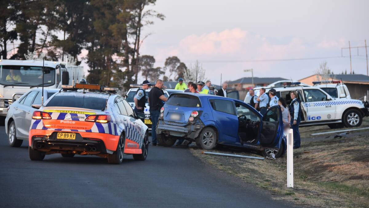 Under arrest: Police at the scene where a man and woman were pulled from the Holden  after it crashed on Post Way outside of Armidale on Wednesday. Photo: Laurie Bullock