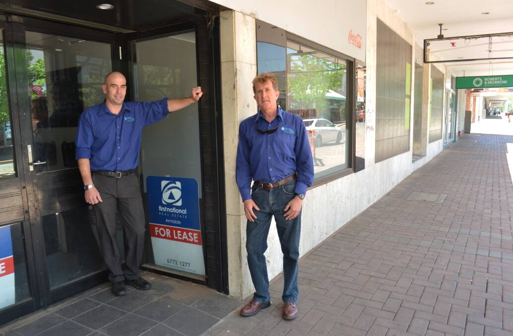 BUSINESSES HURTING: RDANI executive director Nathan Axelsson and senior research economist David Thompson at an empty Armidale shopfront, typical of the wider region.