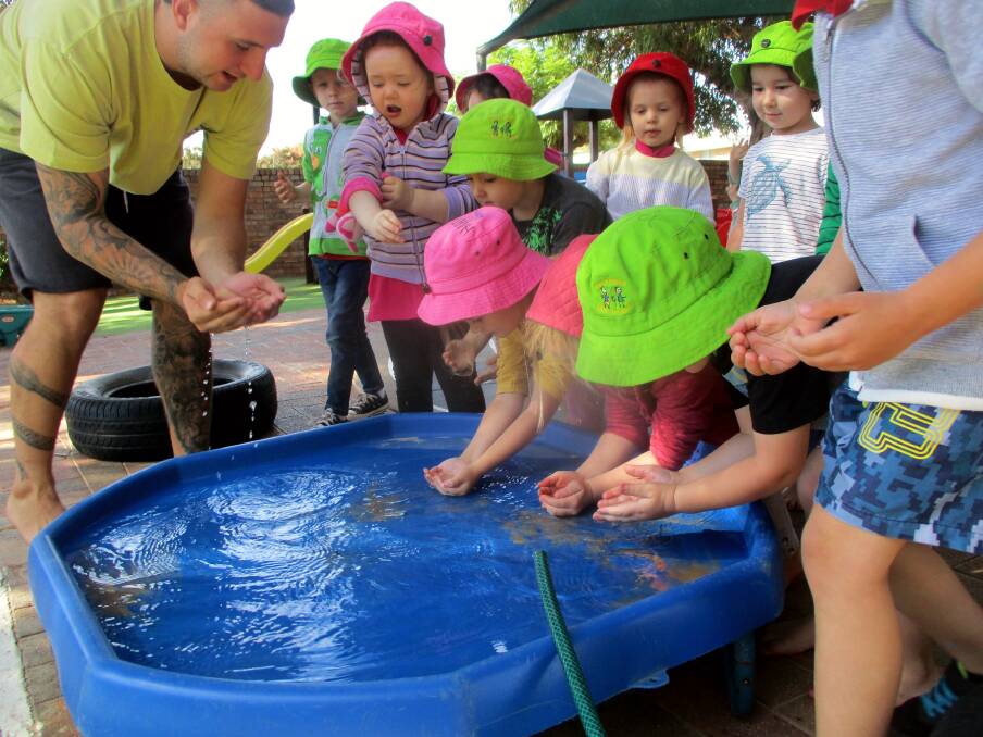 Gamilaroi man James Hogbin, aka Frog, shows pre-schoolers at Mary Ranken how to drink water from a river. Photos: Suplied