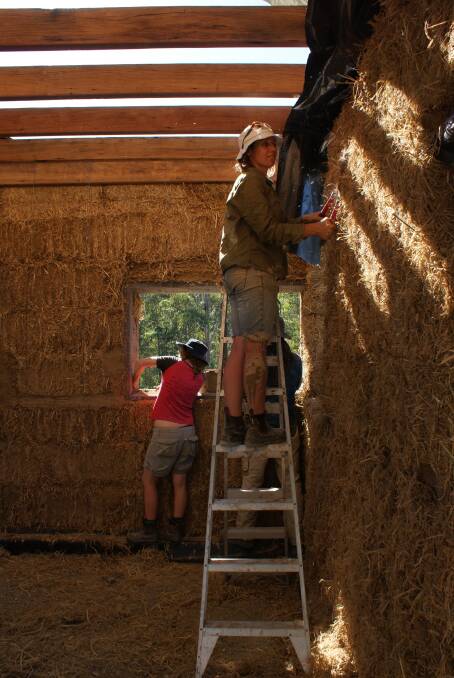 Prue and Jemma strawbaling the agricultural shed during one of the groups working bees. Photo supplied