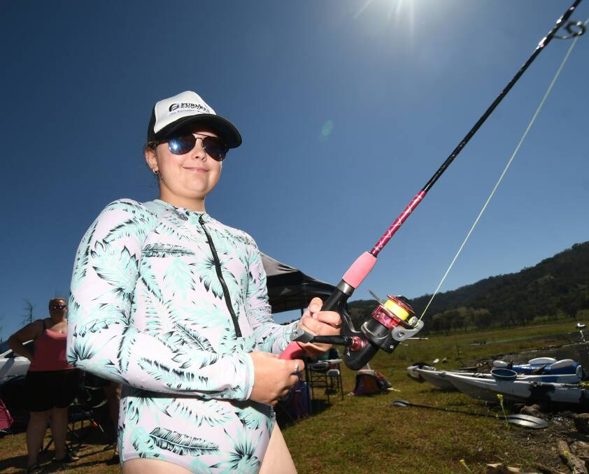 SCORCHER: Mya Kelly was one of the avid anglers taking out their rods to 'catch a carp' on Saturday, taking precautions to stay safe during the heatwave. Photo: Gareth Gardner