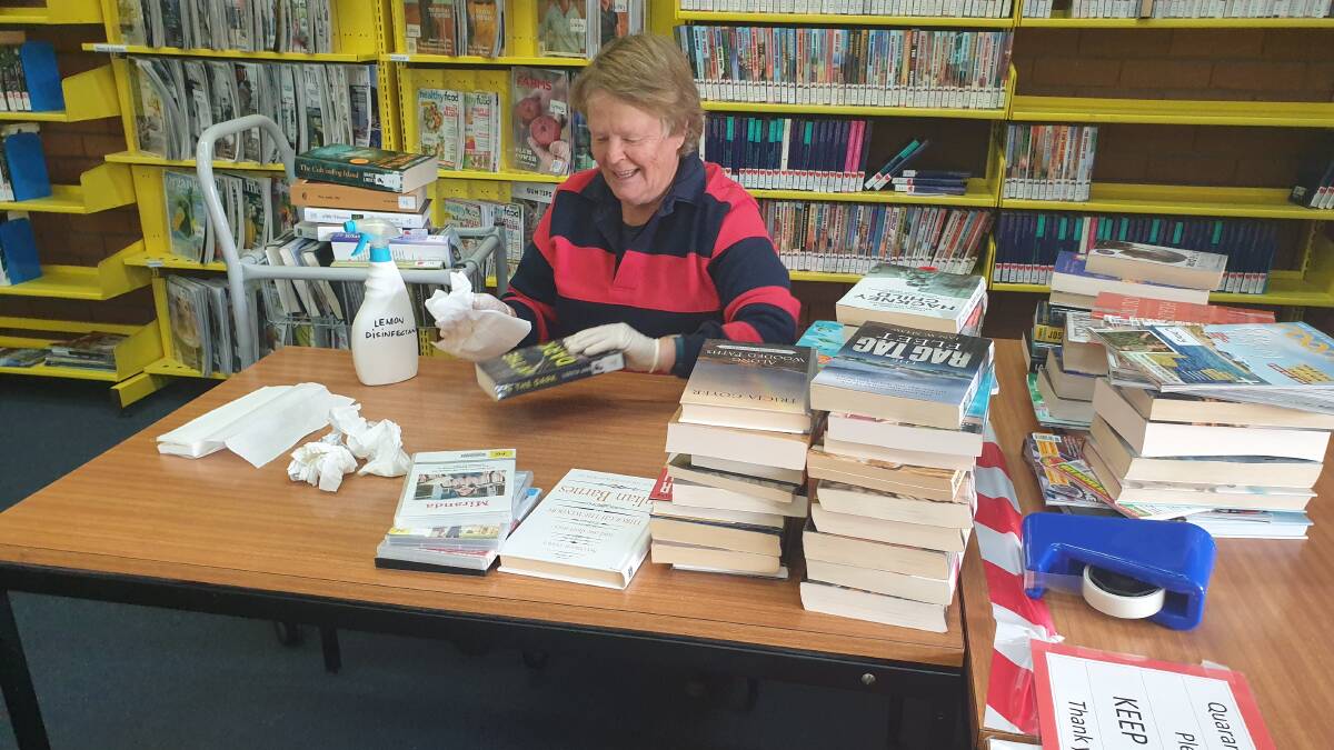 GLOVES ON: Marg Muirson from Quirindi library undergoing the rigorous disinfecting process for the many returns from Click and Collect. Photo: Supplied