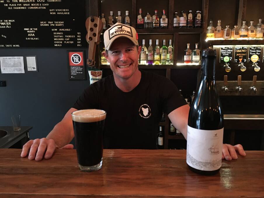 CHEERS: The Welder's Dog owner Ben Coombes laps up the excitement of International Beer Day with a bottle of the limited edition porter. Photo: Billy Jupp 