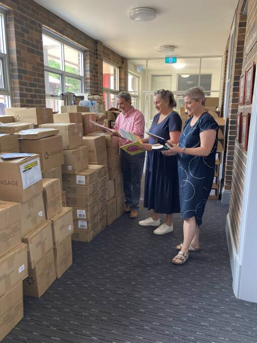 Chris Smyth, education officer Kerrie Priddis and subject matter expert Alicia Pringle reviewing a portion of the new reading books delivered to Armidale diocesan primary schools.