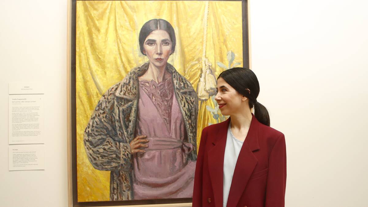 2018 Archibald Prize winner Melbourne artist Yvette Coppersmith poses for a photograph next to her oil and acrylic on linen painting 'Self-portrait, after George Lambert'. Picture: AAP