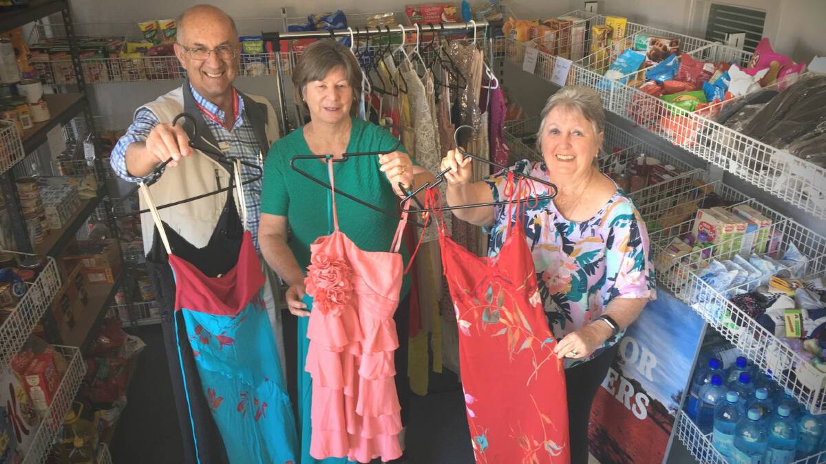 FROCKS: Uniting Church supply minister Will Pearson, and pantry volunteers Gail Brooks and Vera Fielder, with some of the dresses. 