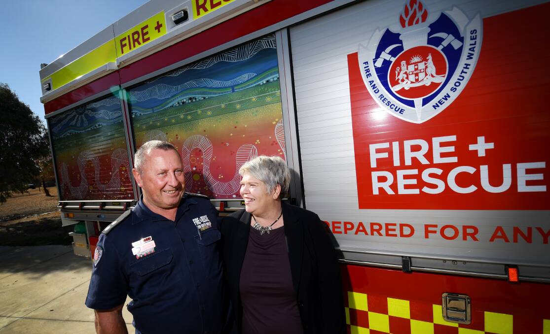 Fire & Rescue NSW New England superintendent Tom Cooper with Indigenous artist Jodie Herden. Her work is being featured on local fire appliances, symbolic of a new partnership strategy launched today. Photo: Gareth Gardner 070618GGB002