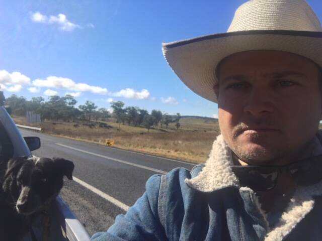 Ben Booth with one of his working dogs - and the distinctive yellow-and-black road signs warning drivers there are cattle on the road.