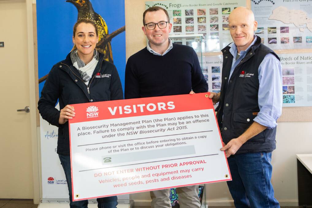 SNAPPED UP: NSW Agriculture Minister Adam Marshall, flanked by Northern Tablelands Local Land Services biosecurity officer Elli Sinclair and general manager Paul Hutchings, with one of the free signs.