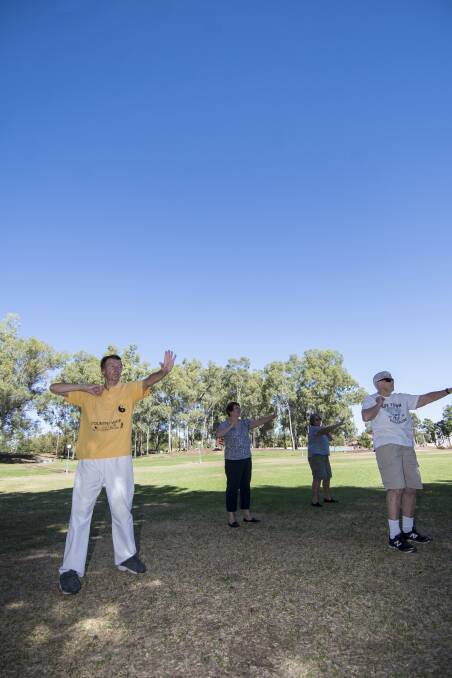 MAKING MOVES: Brian Gregson, left, leads a tai chi session in Bicentennial Park, Tamworth, this morning. Photo: Peter Hardin 120219PHA009